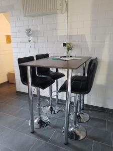 a wooden table with black chairs in a room at Alte Werkstatt - Monteurwohnung auf dem Land in Borken