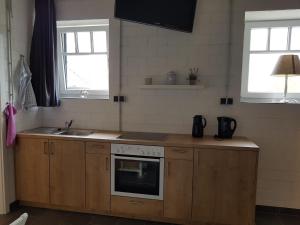 a kitchen with a stove and a sink and two windows at Alte Werkstatt - Monteurwohnung auf dem Land in Borken