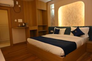 a bedroom with a large bed with blue and white pillows at THE MASARA MANAR Hotel in Gwalior
