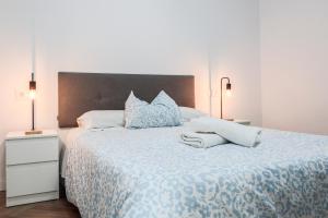 a bedroom with a large bed with blue and white sheets at Algaba Huelva alto in La Algaba