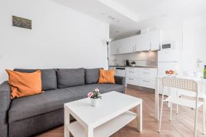 a living room with a gray couch and a white table at Algaba Huelva alto in La Algaba