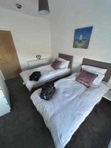 two beds in a hotel room with luggage on them at Spacious Three Bedroom Flat in Filey Town Centre with Workspace in Filey