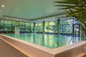 a large swimming pool in a building with windows at Fletcher Hotel-Restaurant Arnsberg-Sauerland in Arnsberg