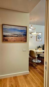 a dining room with a table and a painting on the wall at Sweet Horizon in Quarteira
