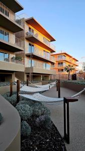 a large apartment building with a hammock in front of it at Sweet Horizon in Quarteira