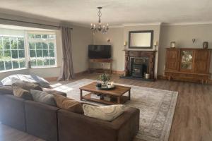 a living room with a couch and a tv at Mountingrovebnb in Piltown