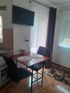 a dining room table and chairs in a room at Holiday Apartman in Bük