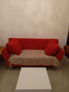 a red couch with two red pillows on it at Studio Appartement without steps and terrace in Görlitz