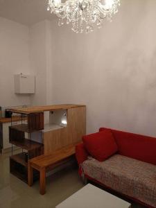 a living room with a red couch and a chandelier at Studio Appartement without steps and terrace in Görlitz