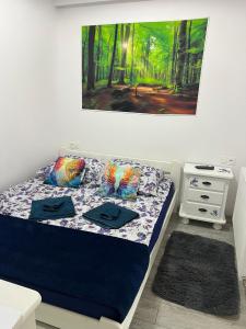 a bedroom with a bed with a painting on the wall at Apartamenty Anielski Sen 3 in Świeradów-Zdrój