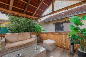 a patio with a couch on a wooden deck at La lukas in Mussy-sur-Seine