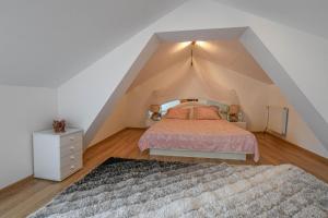 a attic bedroom with a bed and a rug at La lukas in Mussy-sur-Seine