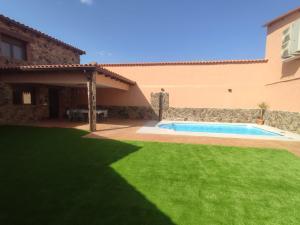 a backyard with a swimming pool and a house at Casa Rural Tomillo in Navalcán
