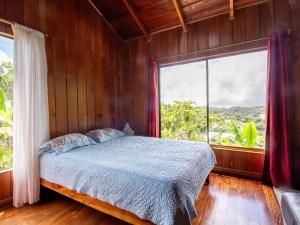 a bedroom with a bed and a large window at Coffee House in Monteverde Costa Rica
