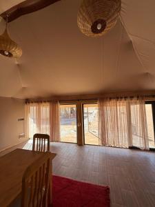 a living room with a table and some windows at Desert Luxury Camp Erg Chigaga in El Gouera +58 photos