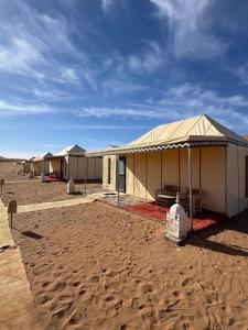 a row of tents in the middle of the desert at Desert Luxury Camp Erg Chigaga in El Gouera