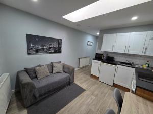 a living room with a couch and a kitchen at 1B Smart Apartments in Newark-on-Trent