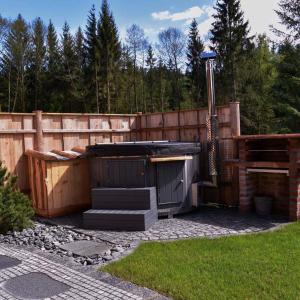 a hot tub in a backyard next to a fence at Chalet Enzian Bayerwald in Arnbruck