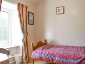 a bedroom with a bed and a window at Hen Ysgol in Llanfaethlu +10 photos