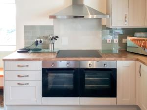 a kitchen with two ovens and a stove top at Hen Ysgol in Llanfaethlu
