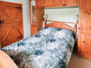 a bedroom with a bed and a wooden door at Hen Ysgol in Llanfaethlu