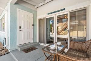 a porch with two wicker chairs and a door at Island Gem A home in Anna Maria