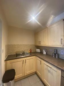 a kitchen with wooden cabinets and a sink at Childes Court in Nuneaton +5 photos