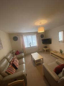 a living room with two couches and a tv at Childes Court in Nuneaton