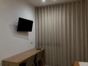 a room with a curtain and a television on a wall at VenereCiprea in Castelbuono