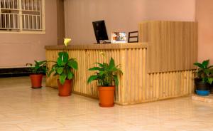 a reception desk with potted plants in a lobby at JD LUXURY HOTEL Jinja in Jinja