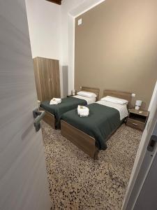 two twin beds in a room with a mirror at Casa Bel Duomo in Gerace