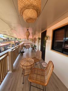 ein Balkon mit Stühlen und Tischen und einem Kronleuchter in der Unterkunft L Casa in Coron