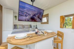 a living room with a table and a tv on the wall at Riverside Suite Mobile Homes in Gradac
