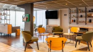 a waiting room with colorful chairs and tables at Campanile NATURE - Bordeaux Lac in Bordeaux