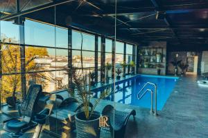 a pool in a building with chairs and windows at Hotel Royal & Spa in Białystok