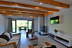 a living room with a couch and a tv at Mimosa Lodge in Montagu