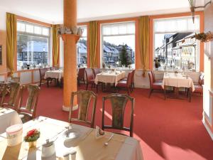 a dining room with tables and chairs and windows at Hotel Kronprinz in Bad Salzdetfurth