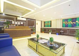 a waiting room with a blue chair and a table at Hotel Decent Suites - Delhi Airport in New Delhi
