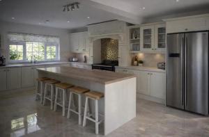 a kitchen with white cabinets and a large island with bar stools at Mountingrovebnb in Piltown