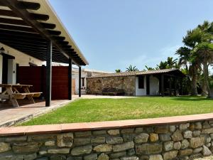 a stone wall next to a house with a picnic table at Apartamentos Villa Pirata Tarifa in Tarifa