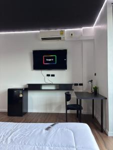 a bedroom with a bed and a tv on a wall at Atrium Kathu Hotel in Ban Kathu (1)