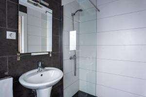 a bathroom with a sink and a glass shower at Hostal On Dormire Valencia in Valencia