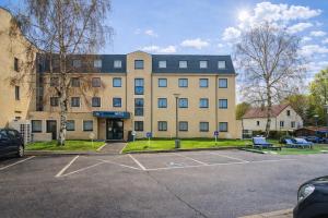 a large building with a parking lot in front of it at Geographotel Paris-Roissy CDG Airport in Le Mesnil-Amelot