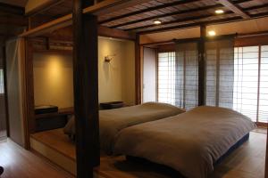 two twin beds in a room with windows at 檸檬草ー奄美の自然の香る宿ー in Amami