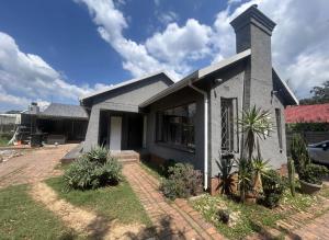 ein Haus mit einer gepflasterten Auffahrt davor in der Unterkunft Madlabeezy in Kempton Park