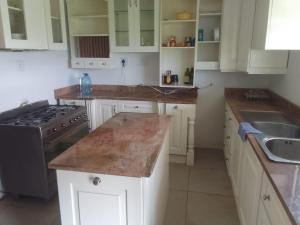 eine Küche mit weißen Schränken und einer Arbeitsplatte in der Unterkunft Madlabeezy in Kempton Park