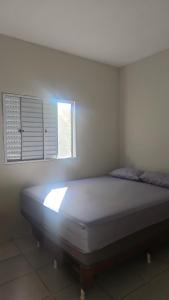 a bed in a room with a window at Casa Itanhaém Praia Cibratel in Itanhaém