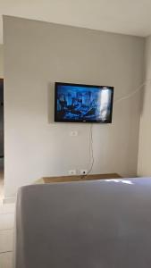 a flat screen tv hanging on a white wall at Casa Itanhaém Praia Cibratel in Itanhaém