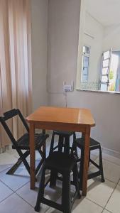a wooden table with two chairs and a mirror at Casa Itanhaém Praia Cibratel in Itanhaém