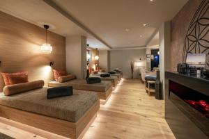 a room with four beds and a fireplace at Residence Angelika in Corvara in Badia